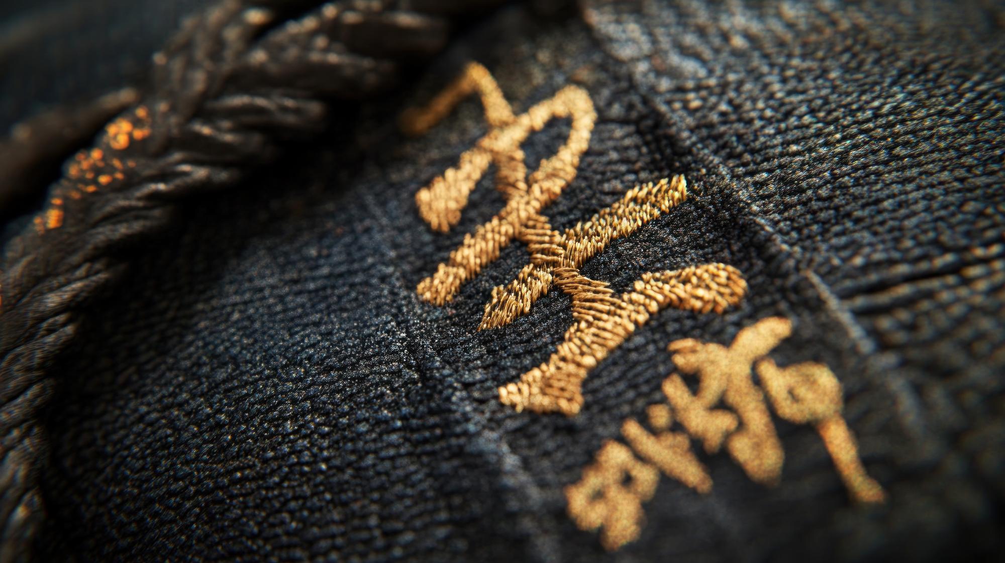 detail of gold thread monogram on jacket